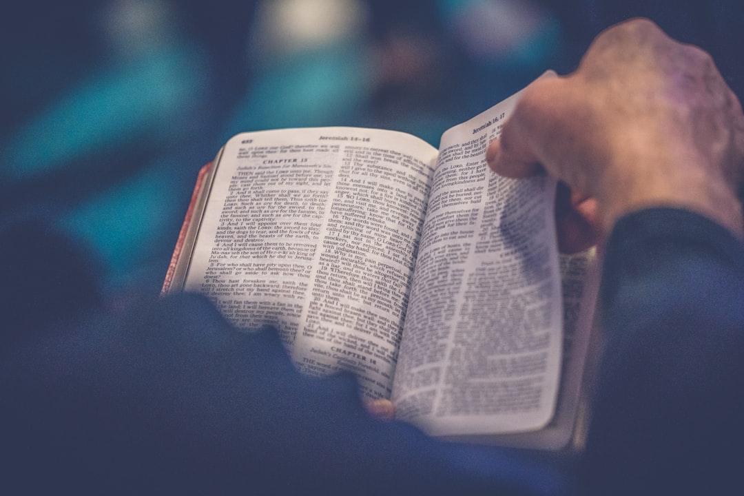 Hands turning pages of an open Bible